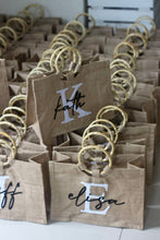 Afbeelding in Gallery-weergave laden, Personalized totes with wooden handles featuring names and initials from Travellers Hat Boutique