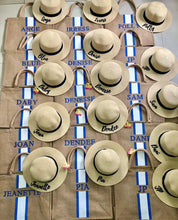 Carica l'immagine nel visualizzatore di Gallery, Custom embroidered round hat collection featuring natural straw color with black bands and personalized names