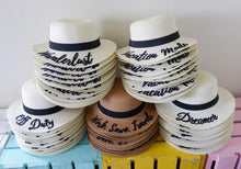 Carica l'immagine nel visualizzatore di Gallery, Custom embroidered round hat collection by Travellers Hat Boutique with various text designs and colors