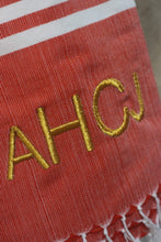 Load image into Gallery viewer, Personalized beach towel in red with gold embroidered initials and white striped edge from Travellers Hat Boutique