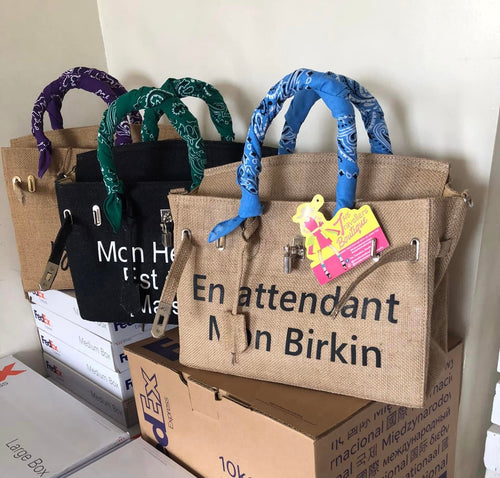 35cm printed burlap bag from Travellers Hat Boutique with colorful bandana handles and black printed lettering