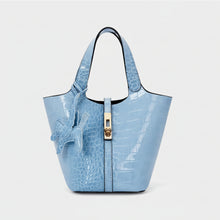 Carregar imagem no visualizador da galeria, Blue crocodile-embossed handbag with a gold clasp on a white background
