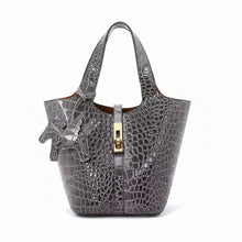 Carregar imagem no visualizador da galeria, Gray crocodile-embossed handbag with gold clasp on a white background
