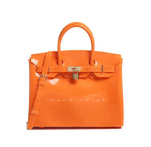 Carregar imagem no visualizador da galeria, Orange personalized Beachkin tote bag from Travellers Hat Boutique with top handles and lock detail
