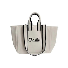 Lataa kuva Galleria-katseluun, Travellers Hat Boutique embroidered boat tote bag in white with black striped handles and Charlie embroidery
