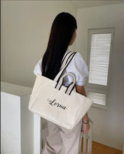 Lataa kuva Galleria-katseluun, Embroidered boat tote bag with black handles and name Lorna on white canvas fabric
