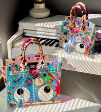 Charger l&#39;image dans la galerie, Travelers Hat Boutique holographic clear tote bag with colorful eye theme designs and wrapped handles
