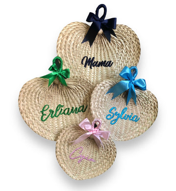 Personalized embroidered abaniko fan set with colorful ribbon bows and custom names on woven straw