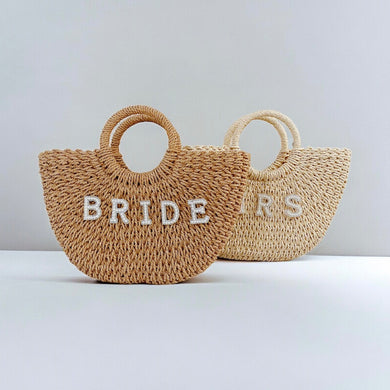 Personalized straw beach bag totes with round handles and bride letters from Travellers Hat Boutique