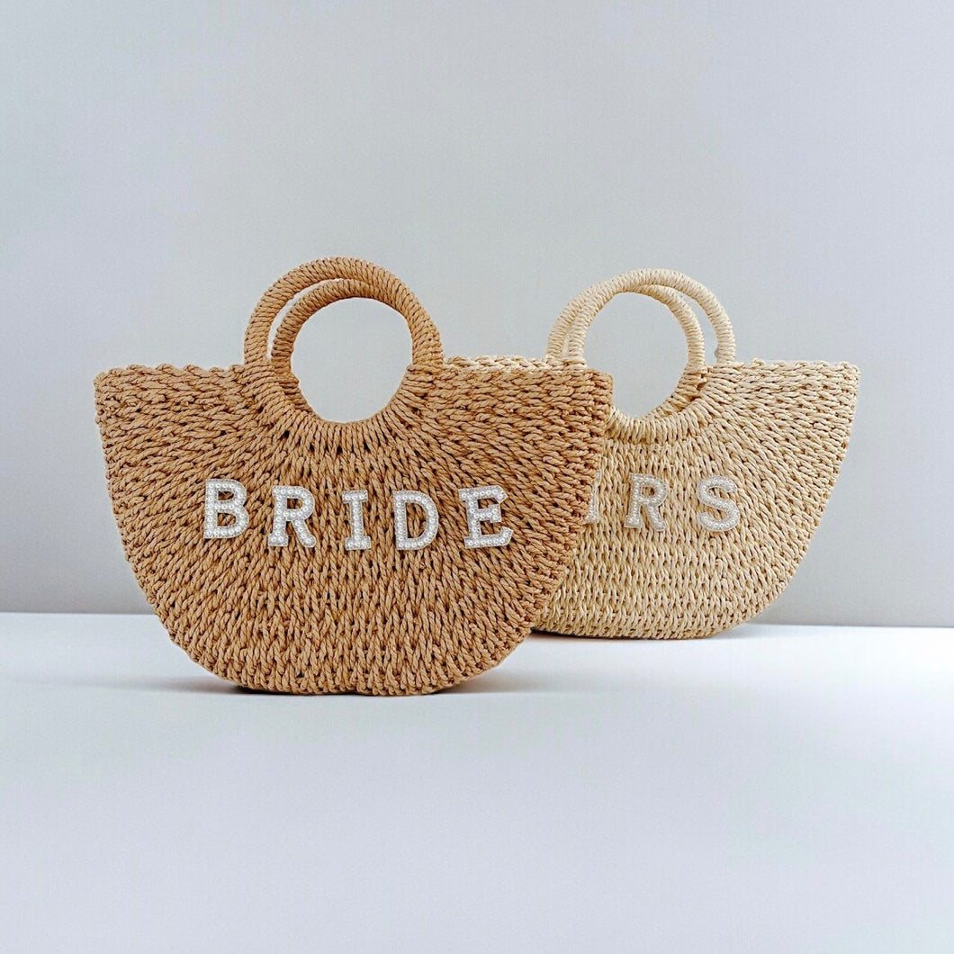 Personalized straw beach bag totes with round handles and bride letters from Travellers Hat Boutique
