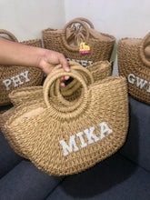 Load image into Gallery viewer, Personalized straw beach bag with circular handles and custom name Mika from Travellers Hat Boutique
