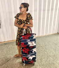 Load image into Gallery viewer, Woman holding floral travel luggage cover with name Lana in navy blue and red colors
