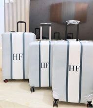 Load image into Gallery viewer, Travel luggage cover with name monogram HF on white suitcases with gray vertical stripes
