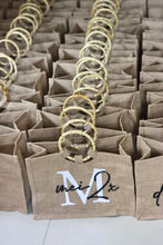 Load image into Gallery viewer, Rows of beige fabric totes with circular wooden handles from Travellers Hat Boutique
