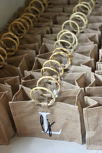 Load image into Gallery viewer, Collection of Travellers Hat Boutique beige jute totes with round bamboo handles and monogram design
