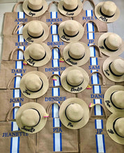 Carregar imagem no visualizador da galeria, Custom embroidered round hat collection featuring natural straw color with black bands and personalized names
