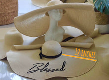 Lade das Bild in den Galerie-Viewer, Oversized straw sun hat with a 12 inch wide brim and black ribbon detail from Travellers Hat Boutique
