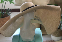 Lade das Bild in den Galerie-Viewer, Oversized straw sun hat with wide brim and black ribbon from Travellers Hat Boutique displayed on mannequin
