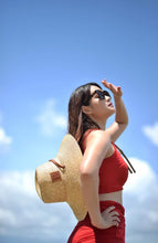Carregar imagem no visualizador da galeria, Woman wearing a panama wheat hat from Travellers Hat Boutique with sunglasses under blue sky
