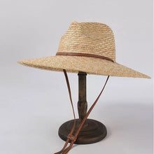 Carregar imagem no visualizador da galeria, Panama wheat hat from Travellers Hat Boutique with wide brim and adjustable brown chin strap
