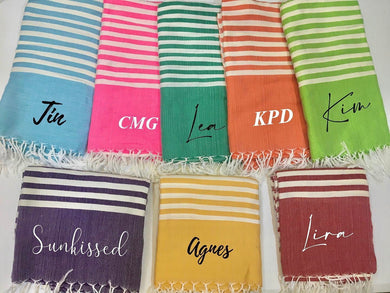 Colorful personalized beach towel collection with names from Travellers Hat Boutique in various striped patterns