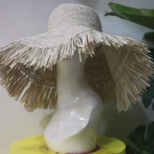 Carregar imagem no visualizador da galeria, Beige raffia crochet sun hat with wide brim and fringed edges displayed on a mannequin head
