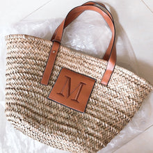 Lade das Bild in den Galerie-Viewer, Travellers Hat Boutique seagrass basket handbag tote with brown leather handles and monogram patch
