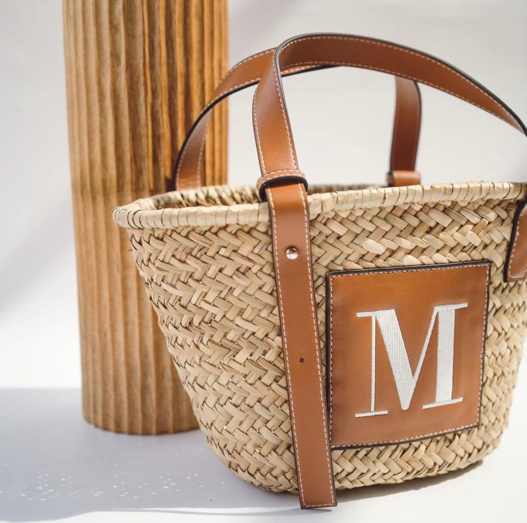 Seagrass basket handbag tote with brown leather straps and monogram M patch by Travellers Hat Boutique