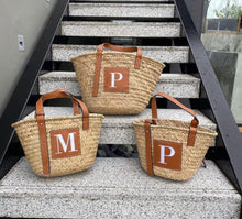 Lade das Bild in den Galerie-Viewer, Set of three seagrass basket handbags with brown leather straps and initial patches by Travellers Hat Boutique
