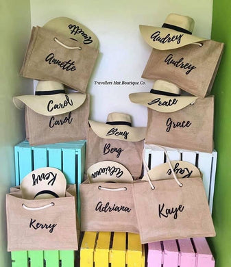 Sustainable jute bags with matching personalized hats displayed on colorful crates by Travellers Hat Boutique