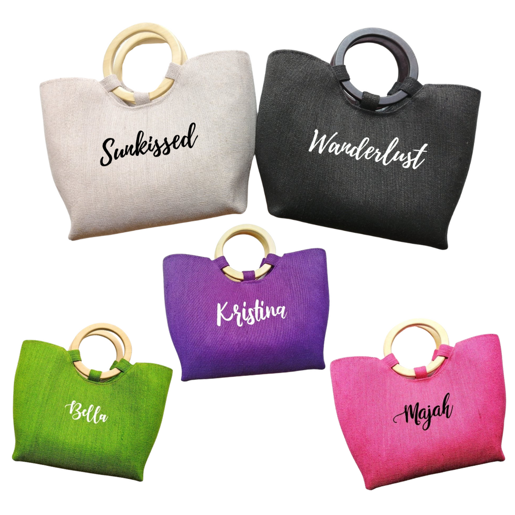 Set of personalized abaca tote bags in beige, black, purple, green, and pink with round wooden handles