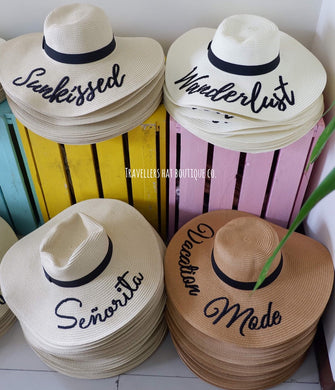 Wholesale floppy sun hats with wide brims and black ribbon bands featuring embroidered words from Travellers Hat Boutique