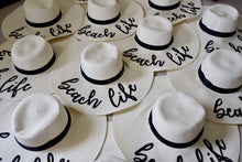Load image into Gallery viewer, Wholesale floppy sun hats in white with black bands and beach life text perfect for summer sun protection
